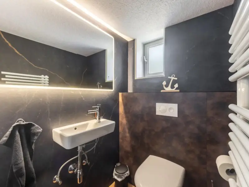 Separates Gäste-WC mit dunklem Wanddekor, Deluxe Apartment