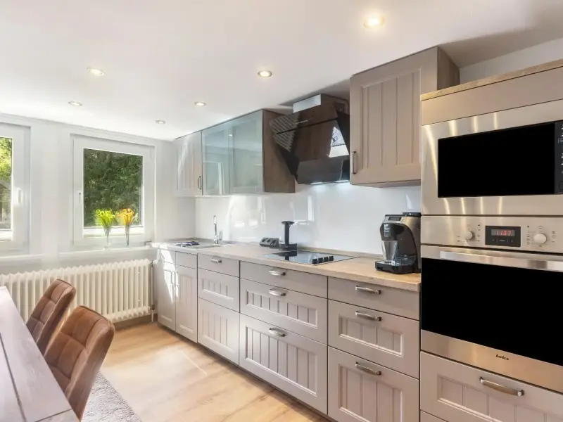 Küchenzeile mit Backofen und Mikrowelle am Fenster, Deluxe Apartment