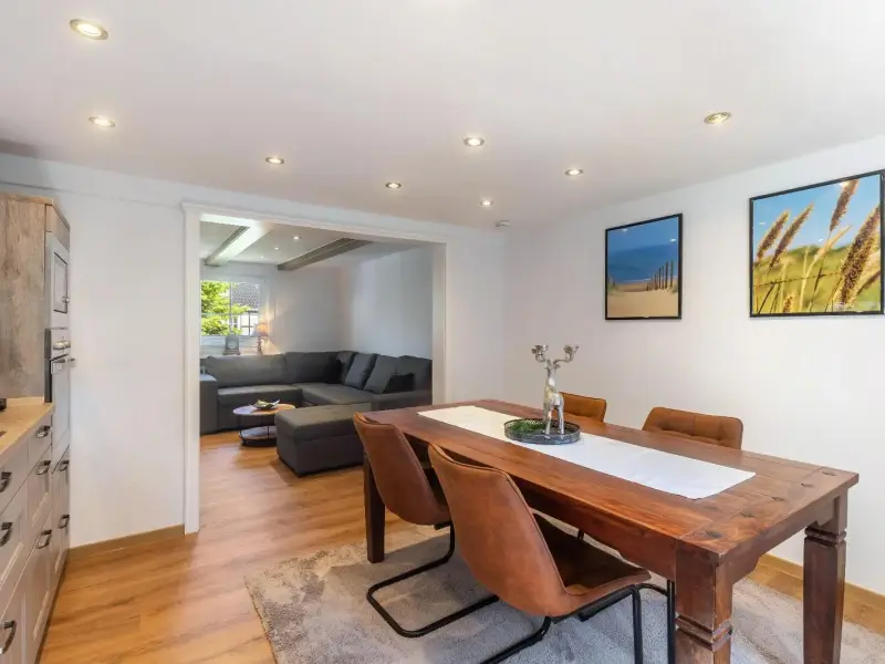 Offener Wohn- und Essbereich mit Holztisch und Blick in die Küche, Deluxe Apartment