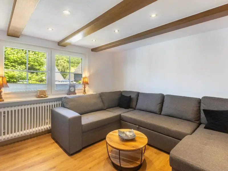 Wohnzimmer mit Eckcouch und Blick ins Grüne, Deluxe Apartment