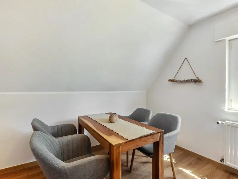 Essecke unter der Dachschräge mit Holztisch und gepolsterten Sesseln, Superior Apartment