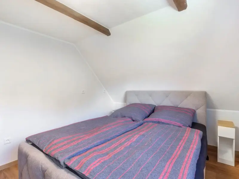 Schlafzimmer unter der Dachschräge mit sichtbarem Holzbalken, Superior Apartment