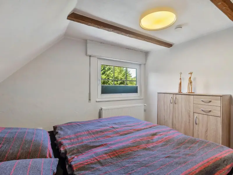 Schlafzimmer mit Kommode und Fensterblick ins Grüne, Superior Apartment